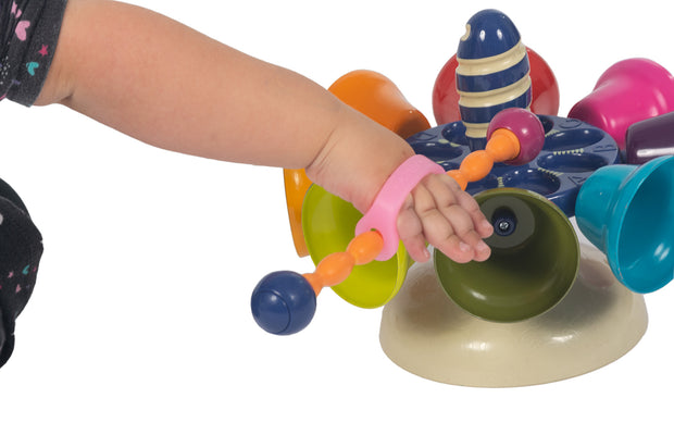 Child playing with bells using a pink eazy hold to grasp the toy.