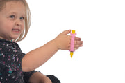 Little girl with grip issues hold a crayon adapted with a pink eazyhold silicone cuff