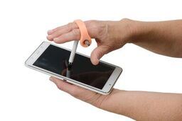 Woman holds an orange eazyhold adaptive stylus and is writing on an i-pad