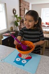 Girl with a limb loss disability stirring a bowl of cake batter with an adapted spoon.