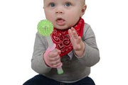 Baby easily holding a toy and playing with an eazyhold pink adaptive cuff