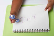 Child with limb loss writing with an adapted marker