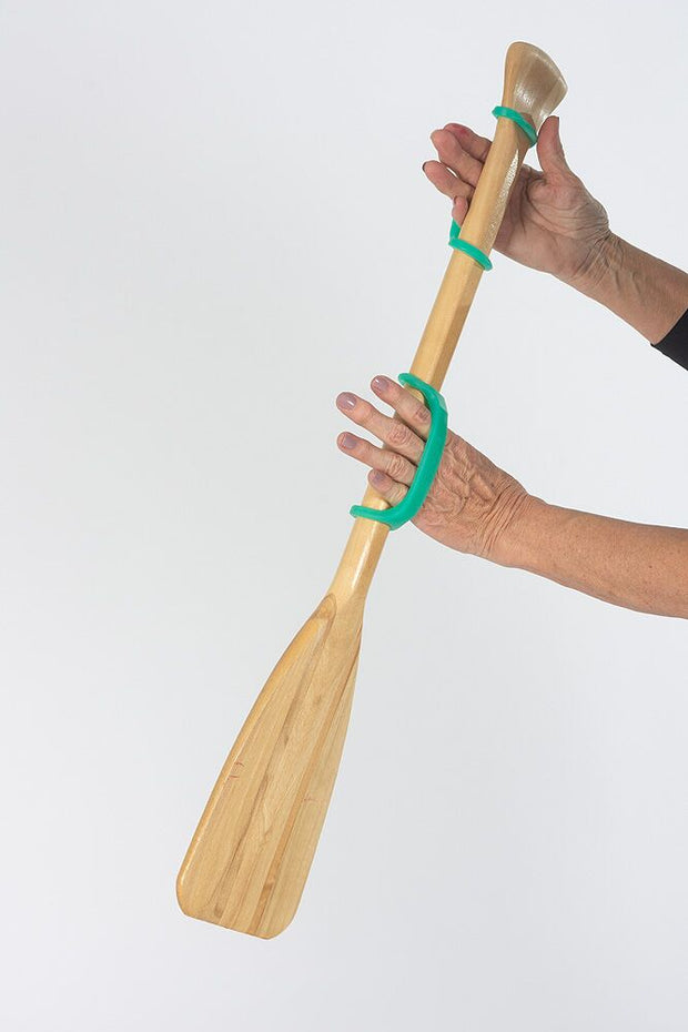 Hands holding a boat oar with 2 aqua eazyhold adaptive aids 
