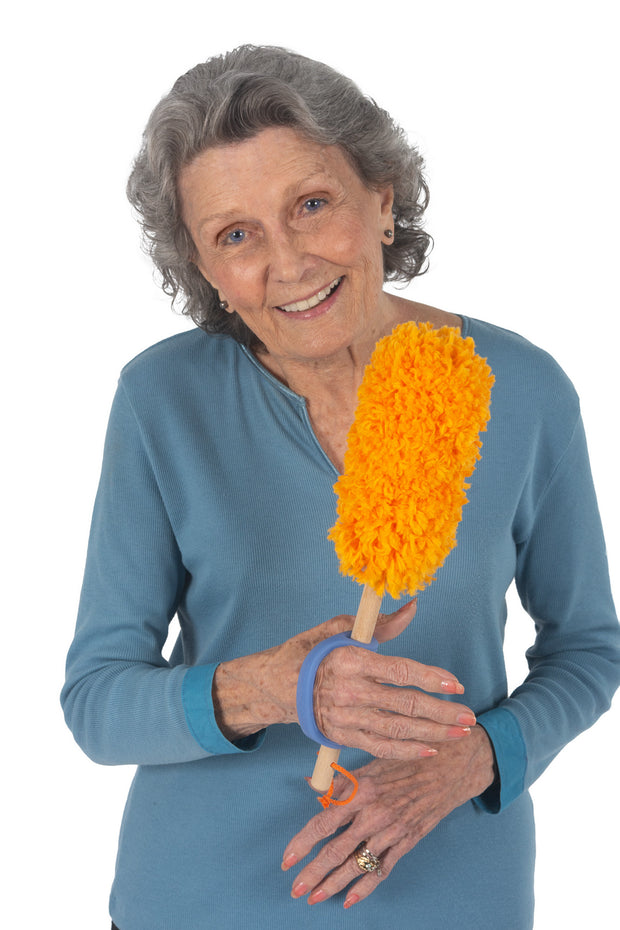 Woman with reduced grip holding a duster with the help of an ADL assistive device 