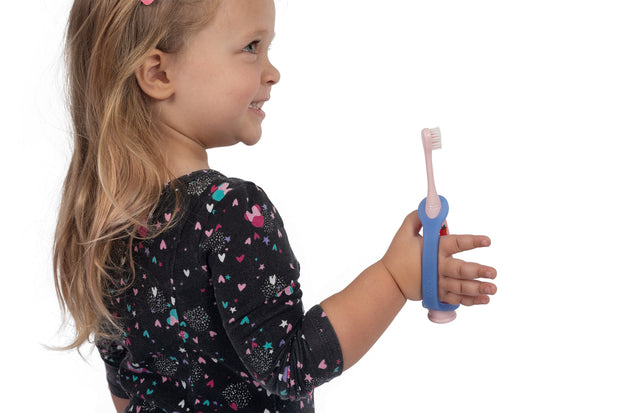 Little girl holding an adapted electric toothbrush with a blue eazyhold.