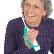 Woman with arthritis holding an electric toothbrush with an aqua eazyhold silicon grip aid.